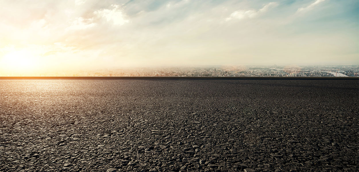 Asphalt on a road with a sunrise in the background. Associated Asphalt's Corporate Citizenship