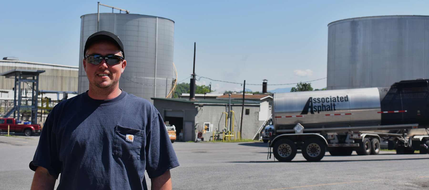 Daniel Palmer, Terminal Manager at Associated Asphalt Roanoke standing in front of a terminal and tanker truck.