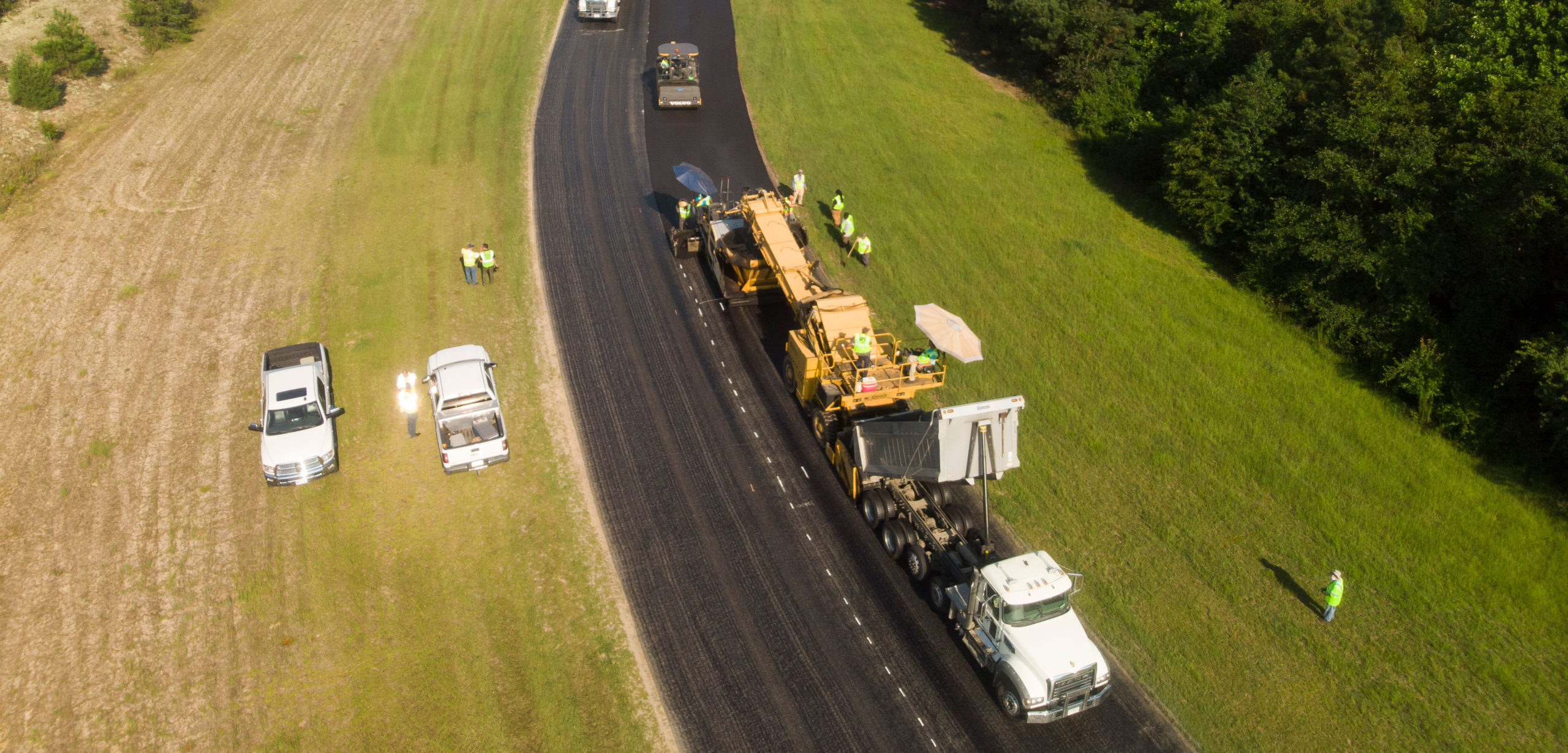 An overhead view of asphalt crews and vehicles repaving a turn at Carolina Motorsports Park.