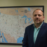Associated Asphalt Transportation Manager Ernie Hamilton, Sr. in front of a United States map.
