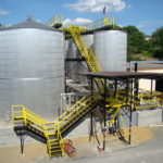 A group of large emulsion silohs with a yellow stair system in Roanoke, Virginia.
