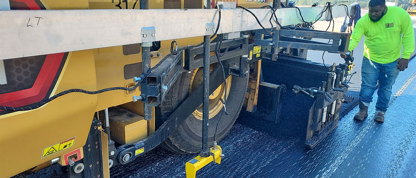 A crew member operating moving asphalt equipment at Hubota Test Track in Gainesville.